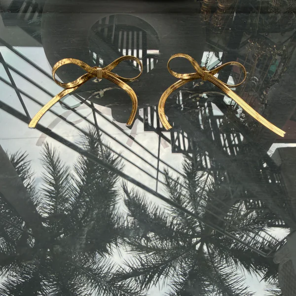 Golden Bow Studs - Earrings from BLINGARI luxury Indian fashion collection